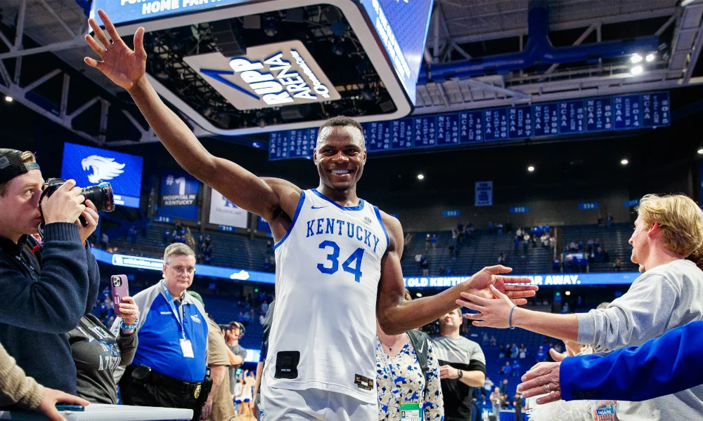 Oscar Thsiebwe celebrating with Kentucky basketball fans at Rupp Arena.