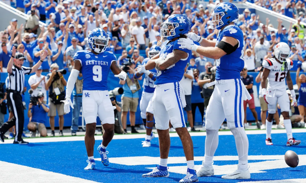 Tayvion Robinson and Brenden Bates celebrating with Dane Key after a Kentucky touchdown at Kroger Field.