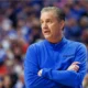 Kentucky basketball coach John Calipari with his arms crossed as he observes his team at Rupp Arena.