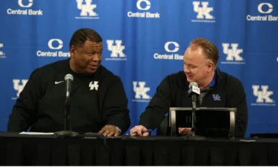 Vince Marrow and Mark Stoops talking to the media at a Kentucky Football press conference.