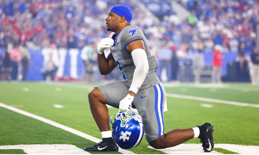 Kentucky Wildcats linebacker Jamon Dumas-Johnson (2) makes the sign of the cross while taking a knee before the game.